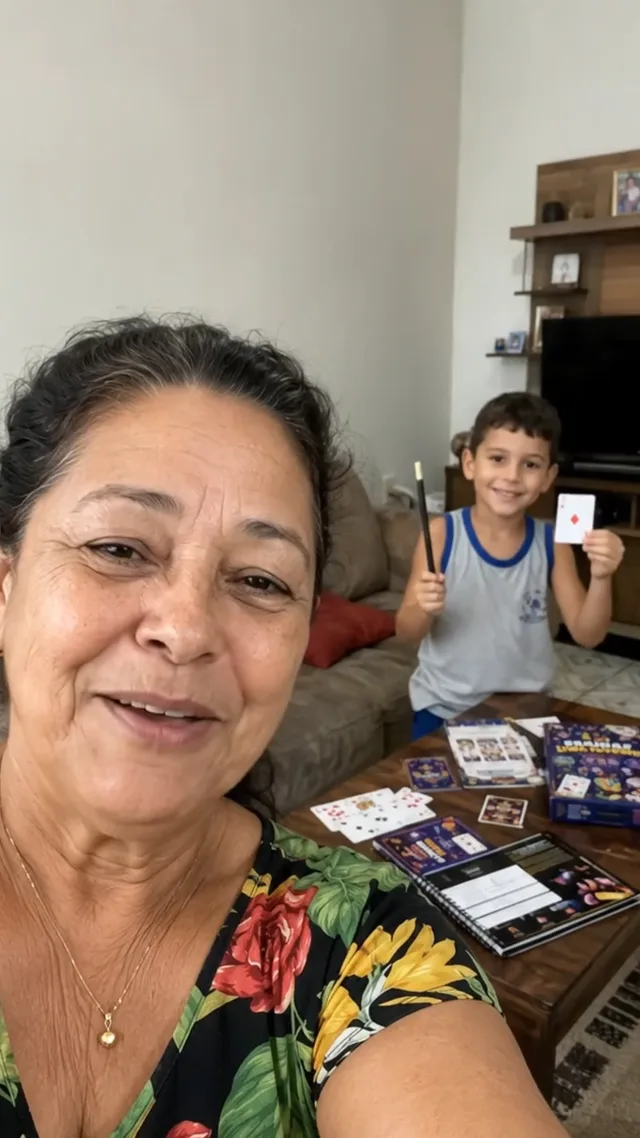Avó sorrindo com o neto ao fundo mostrando uma carta e a varinha