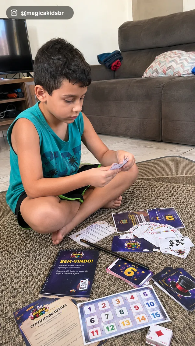 Menino concentrado treinando os truques de cartas sozinho no chão